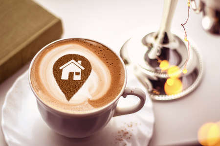 a cup of cappuccino coffee with a picture of the location of the house on milk foamの写真素材