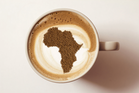 A cup of cappuccino coffee with a pattern on milk foam from cinnamon in the form of Africaの写真素材