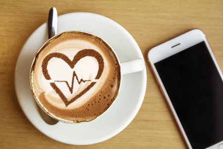 Heart with cardiogram line made on a cup of coffee