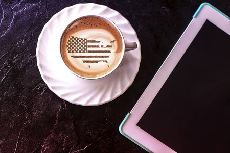 Flag of the United States of America in the form of territorial borders on a cappuccino coffee cup close-upの写真素材