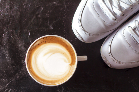 a cup of cappuccino coffee in a ceramic cup on the tableの写真素材