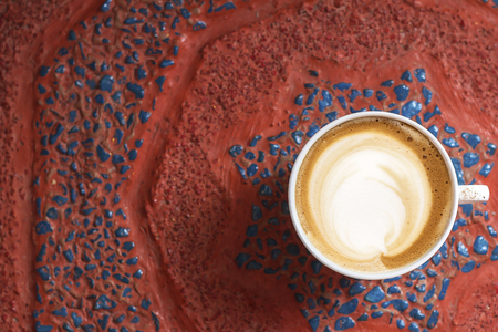 a cup of cappuccino coffee in a ceramic cup on the tableの写真素材