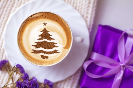 cup of Christmas cappuccino coffee with a Christmas tree patternの写真素材