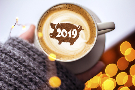 coffee cappuccino in a cup with a pattern of the symbol of 2019 pig on milk foam. The pig is a symbol of the year 2019 in the Chinese calendar.の写真素材