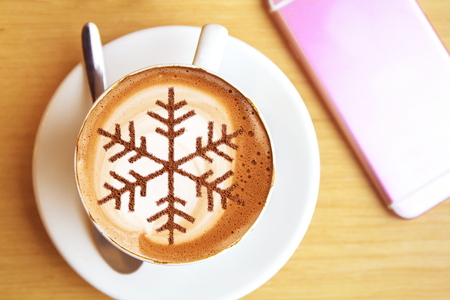 Cappuccino with a pattern of snowflakes from cinnamon on milk foam during Christmas holidays coffee for christmasの写真素材