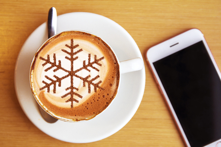 Cappuccino with a pattern of snowflakes from cinnamon on milk foam during Christmas holidays coffee for christmasの写真素材