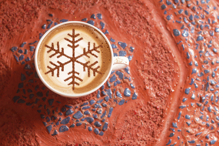 Cappuccino with a pattern of snowflakes from cinnamon on milk foam during Christmas holidays / coffee for christmasの写真素材