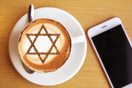 A cup of coffee in Israel cappuccino with a picture of the star of Davidの写真素材