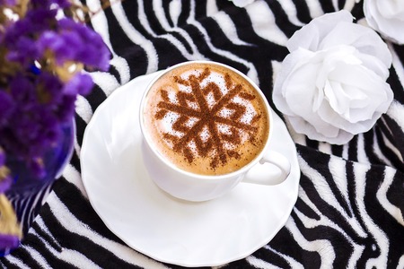 Cappuccino with a pattern of snowflakes from cinnamon on milk foam during Christmas holidays, coffee for christmasの写真素材