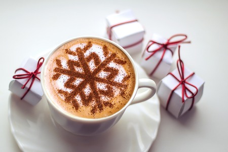 Cappuccino with a pattern of snowflakes from cinnamon on milk foam during Christmas holidays, coffee for christmasの写真素材