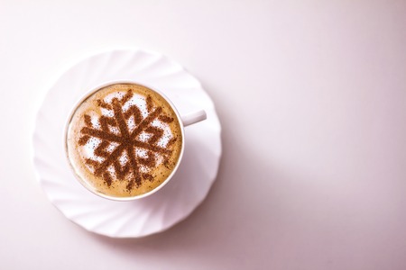 Cappuccino with a pattern of snowflakes from cinnamon on milk foam during Christmas holidays, coffee for christmasの写真素材