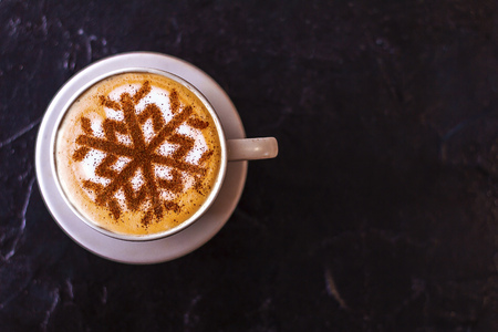 Cappuccino with a pattern of snowflakes from cinnamon on milk foam during Christmas holidaysの写真素材
