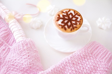 Cappuccino with a pattern of snowflakes from cinnamon on milk foam during Christmas holidays