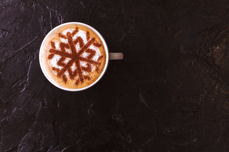 Cappuccino with a pattern of snowflakes from cinnamon on milk foam during Christmas holidaysの写真素材