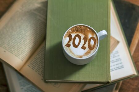 Figures 2020 as a symbol of the New Year on cups of hot aromatic coffee on a bright red background among stars and marshmallows. Top view, flat layの写真素材