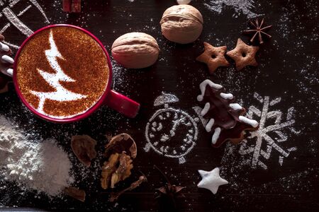 Rustic wooden background with cup of hot coffee and gift wrapping of Christmas cookies. Seasonal background shot from above. Flat lay, top view, filtered image. Tag mockup, copy space on the tags.の写真素材