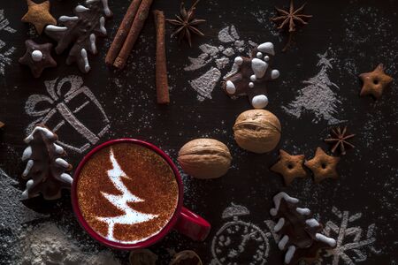 Rustic wooden background with cup of hot coffee and gift wrapping of Christmas cookies. Seasonal background shot from above. Flat lay, top view, filtered image. Tag mockup, copy space on the tags.の写真素材