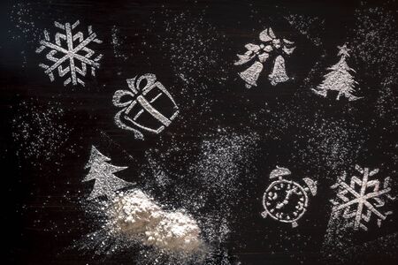 Christmas tree shapes surrounded by powdered sugar on a slate, creative concept with copy space on both sidesの写真素材