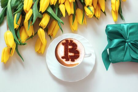 coffee cappuccino in a white cup with a symbol Bitcoin of cinnamon on milk foam