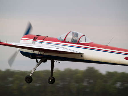 Small aerobatics plane performing speed pass low altitude