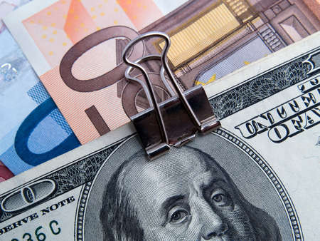 US dollars and euros binded by paper-clipの写真素材