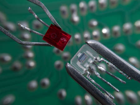 Optocoupler and LED in pincers electronic assembly macroの写真素材