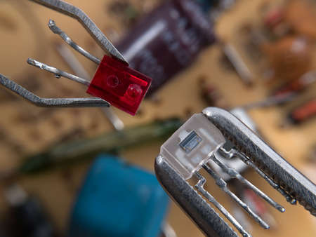 Optocoupler and LED in pincers electronic assembly macroの写真素材