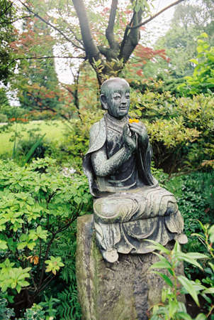 Small bronze buddha statue in japanese gardenの写真素材