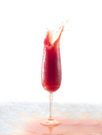 Tomato juice splash in glass white backgroundの写真素材