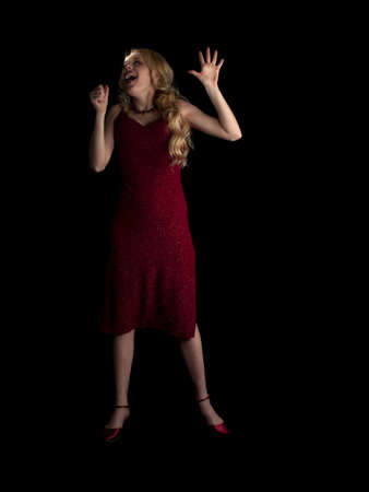 Beautiful blonde young lady in red dress singingの写真素材