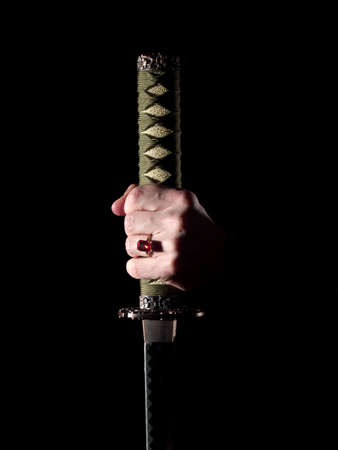 Japanese katana sword in man's hand in darknessの写真素材
