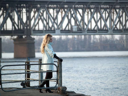 Beautiful blonde lady in overcoat on promenadeの写真素材