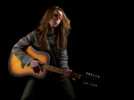 Young long hair guitarist plays hard rock