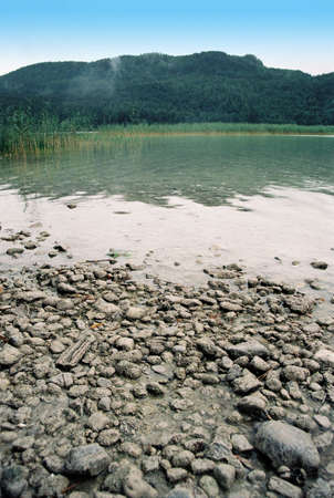 Wild mountain lake weissensee shore with blue skyの写真素材