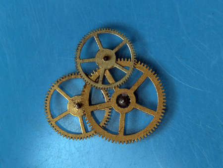 Group of cogwheels rotating in one mechanism on blue background
