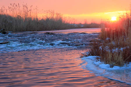 Dawn over Rushing winter riverの写真素材