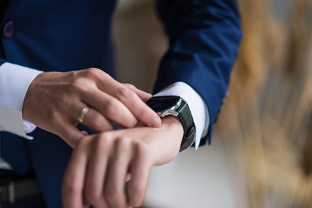 businessman checking time on his wrist watch, man putting clock on hand,groom getting ready in the...