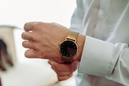 businessman checking time on his wrist watch, man putting clock on hand,groom getting ready in the...
