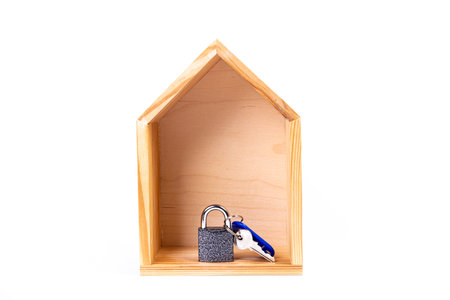 House symbol with metal key on white background. Real estate, insurance concept, mortgage, buy sell house, realtor concept. Isolated, wooden house, symbol of life. housewarming, lock and keychainの写真素材