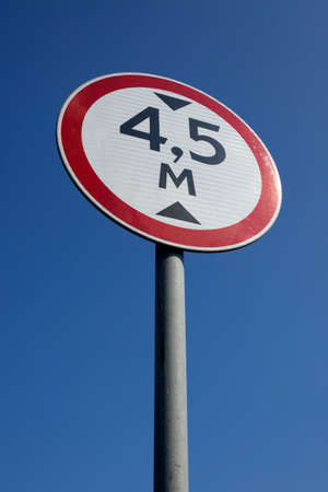 There is a regulatory-sign on a road under blue sky.