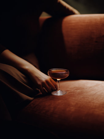 Close up of woman sitting on a sofa and holding a glass of wine.の素材