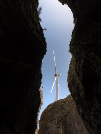 Low angle view of a wind turbine between cliffs. Natural wind electric energy.の素材
