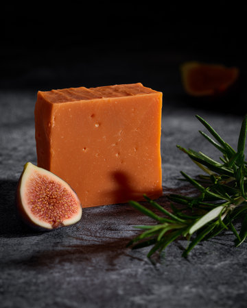 A piece of handcrafted natural soap with fig sits on the table. Daily hygiene.の素材