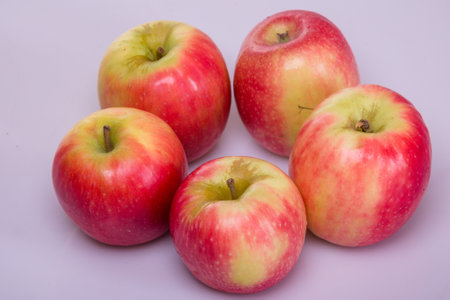 Ripe red apples on a purple background. Close-up.