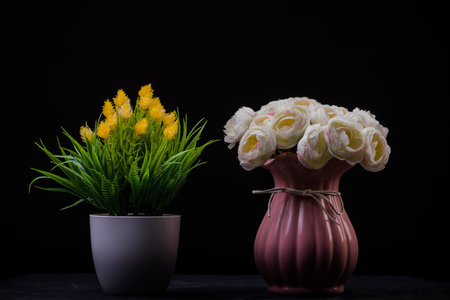 Still life with artificial flowers in a vase on a black backgroundの写真素材