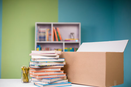 Stack of books on the desk in the classroom. Education concept.