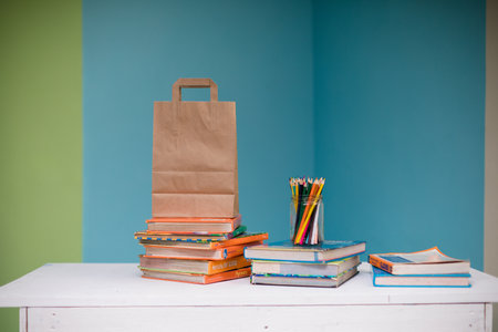 Back to school concept. Stack of books, pencils and paper bag on the table.の写真素材