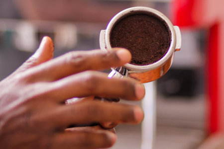 Close-up of a male hand holding a grinder with ground coffeeの写真素材