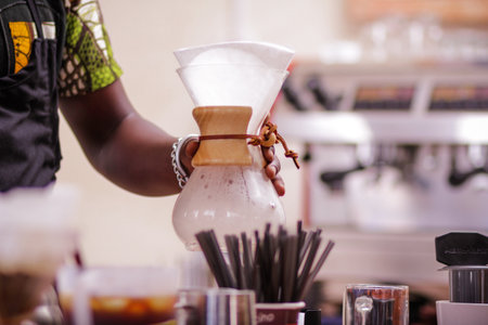 Close-up of barista pouring coffee from coffee grinder in the coffee shop