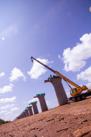 Crane and building construction site on blue sky background. Construction concept.の写真素材